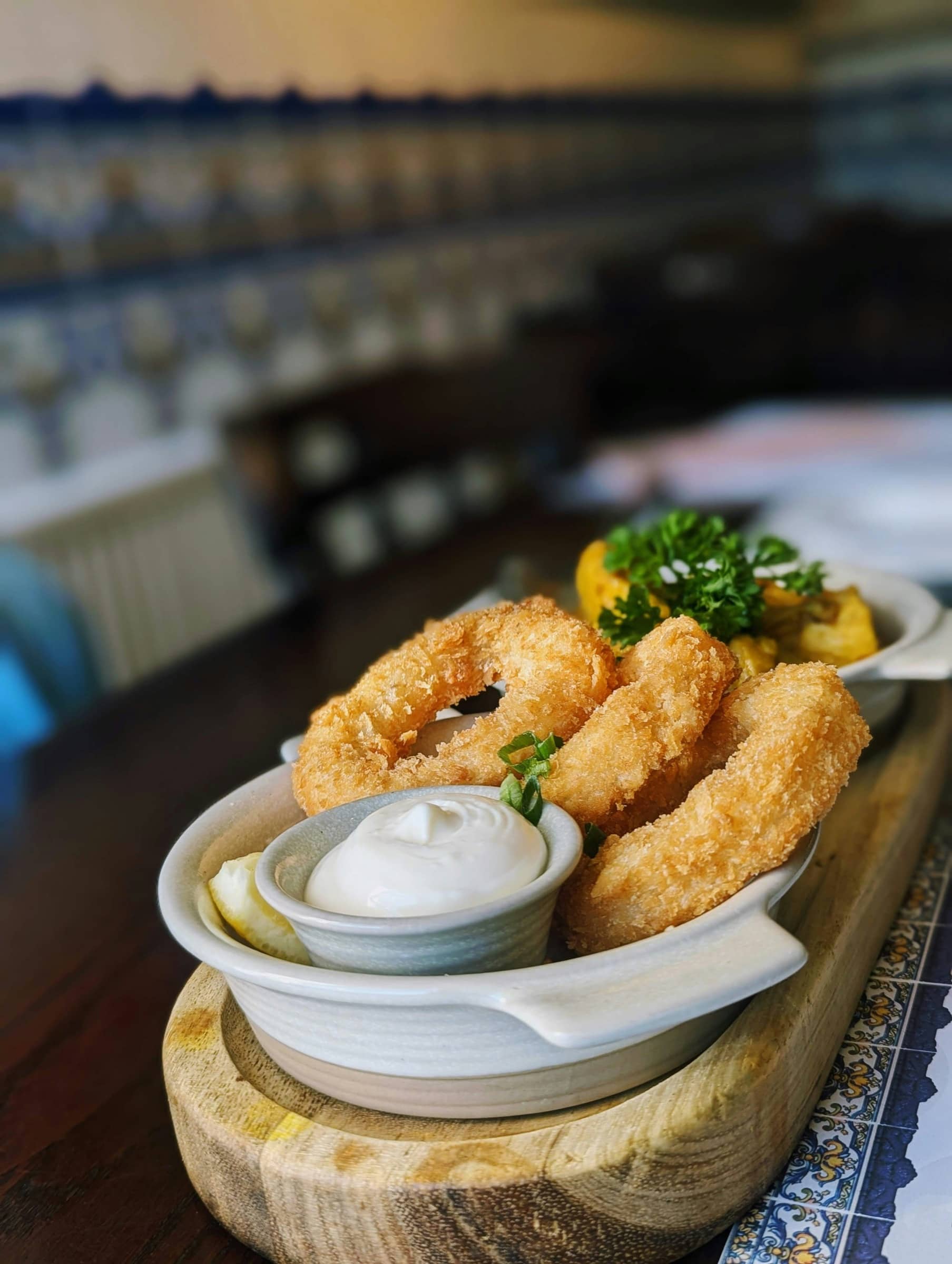 Calamars frits et aïoli devant un mur d'azulejos